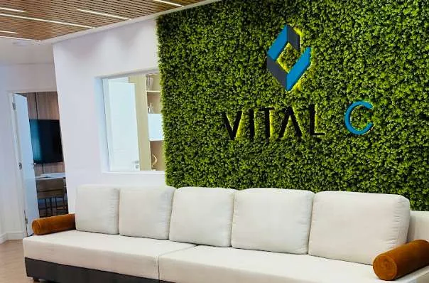 Recepção do escritório da Vital C, com o logo na parede